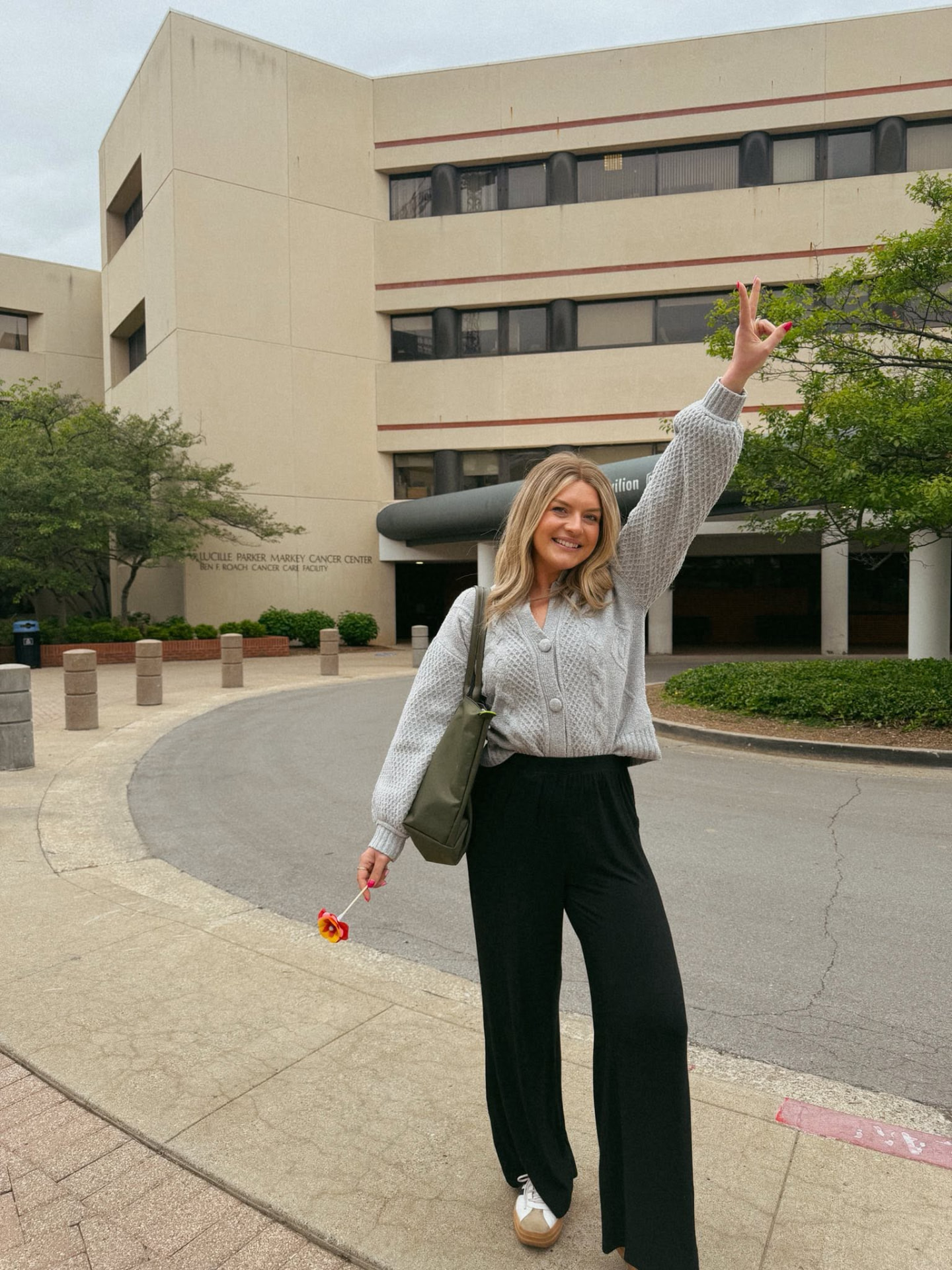Kristin outside the Markey Cancer Center, throwing a peace sign