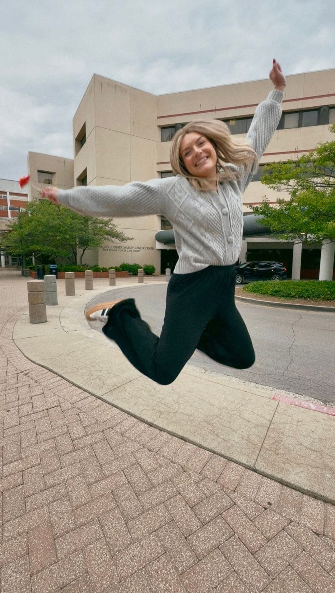 Kristin jumping for joy outside the cancer center